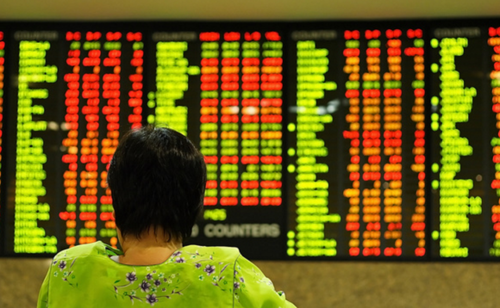 Ecran de trading et femme trader indecise
