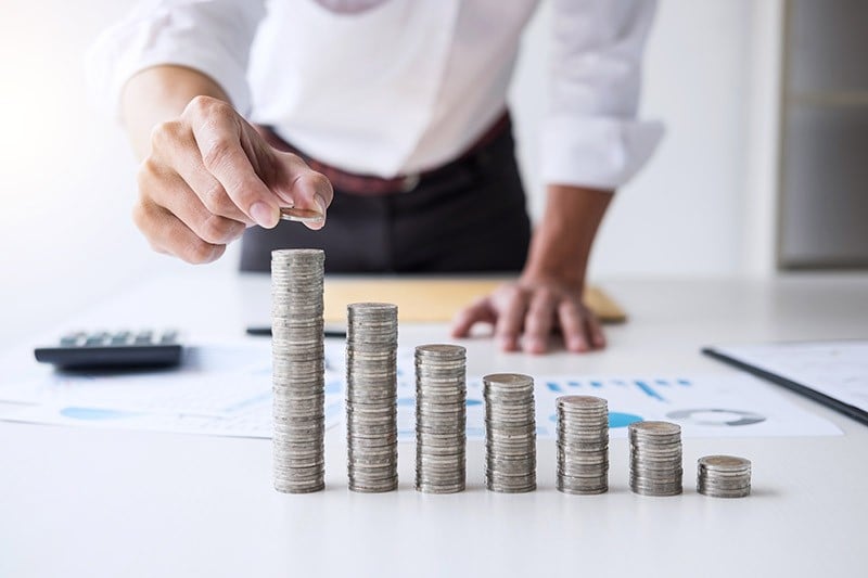 une rangée de pièces de monnaie imitant la hausse d'un graphique boursier