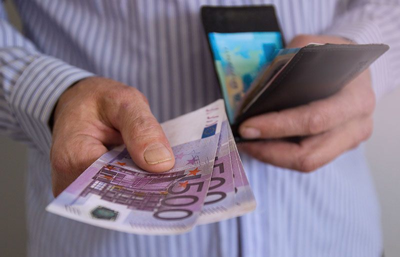 une personne montrant deux billets de 500 euros